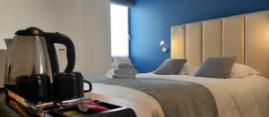 1 dormitorio con 2 camas y pared azul en Hôtel Villa Des 2 Caps, en Wimereux