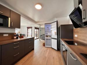 a kitchen with brown cabinets and a refrigerator at Auszeit im Gartenweg in Neuweiler