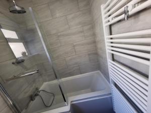 a bathroom with a shower and a sink and a tub at The Collingwood Guest House in Great Yarmouth