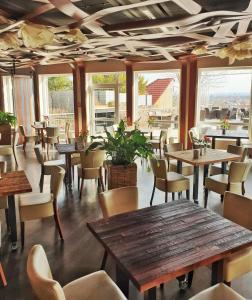 ein Restaurant mit Tischen, Stühlen und Fenstern in der Unterkunft Bergwirtschaft Wilder Mann Hotel und Restaurant in Dresden