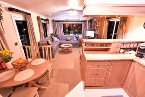 a kitchen and living room with a couch and a table at 57 Peaceful Corner Caravan in Balminnoch