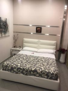 1 dormitorio con 1 cama con edredón blanco y negro en La Massaria B&B affittacamere riservatissimo en San Michele di Serino