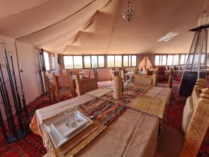 a room with a tent with a table in it at Amskou Camp in Merzouga