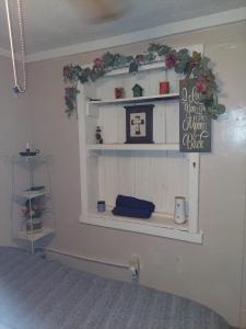 ein Regal an einer Wand mit Blumen und einem Schild in der Unterkunft Overlook Cottage in Hampton