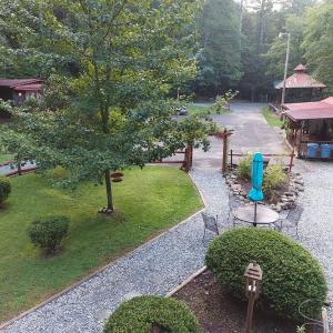 einen Blick über einen Park mit einem Baum und Stühlen in der Unterkunft Overlook Cottage in Hampton