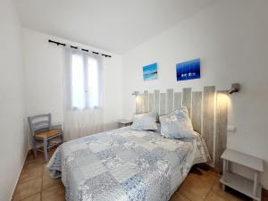 een slaapkamer met een bed met een blauw en wit dekbed bij ***Maison de 38m² -400m Plage- avec Jardin*** in Le Brusc