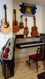 a room with guitars on the wall and a piano at Albergue Albor in Caldas de Reis