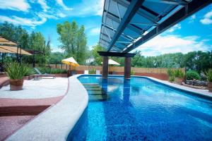 a swimming pool in a backyard with a roof at Villas Casa de Aves in San Miguel de Allende