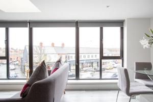 un soggiorno con sedie e una grande finestra di Fabulous Penthouse, Brilliant Location, Sleeps 6! a Belfast