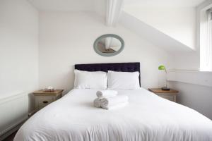 a white bed with a teddy bear sitting on it at Fabulous Penthouse, Brilliant Location, Sleeps 6! in Belfast