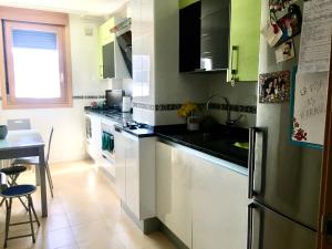a kitchen with a stainless steel refrigerator and a table at Burgos Rachel Swim & Paddle in Burgos