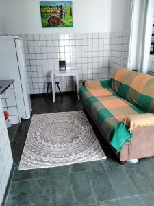 Cette chambre comprend un lit et une table avec un tapis. dans l'établissement Suíte 08 - Aconchegante e Exclusiva, à Cuiabá