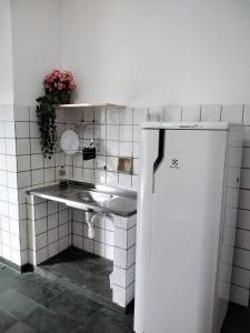eine kleine Küche mit Spüle und Kühlschrank in der Unterkunft Suíte 08 - Aconchegante e Exclusiva in Cuiabá