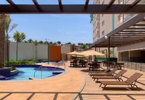 a patio with chairs and a pool with tables and umbrellas at Olímpia Park Resort Enjoy in Olímpia