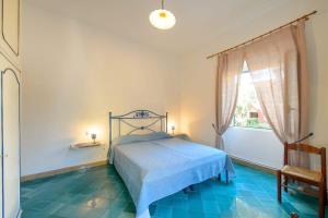a bedroom with a bed with a blue tile floor at La Casa del Sole sul mare di Ischia in Ischia