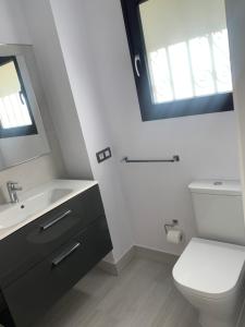 a bathroom with a toilet and a sink and a mirror at CASA ME ENCANTA in Playa de las Americas