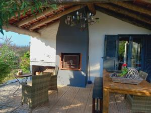 a patio with a table and chairs and a fireplace at Vale de Garcia in Colos