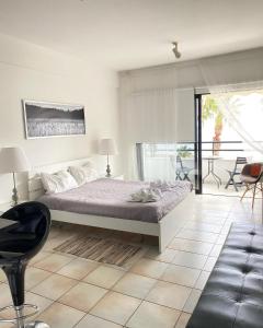 a bedroom with a bed and a table and chairs at Krasas Beach Apartments in Larnaca