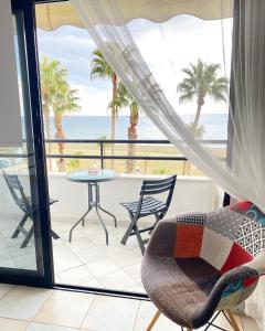 a balcony with a table and chairs and the ocean at Krasas Beach Apartments in Larnaka