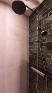 a bathroom with a shower with a black tile wall at Gastenverblijf Nummer 1 Sommelsdijk in Sommelsdijk +19 photos