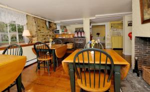 a kitchen and dining room with a table and chairs at Yankee Peddler Inn in Newport