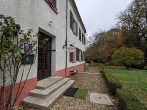 a building with a door and stairs next to a yard at Moulin de Belle Isle in Bèze