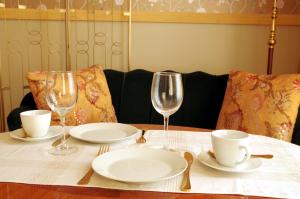 a table with plates and glasses on a table at Amalie Apartment in Haapsalu +9 photos