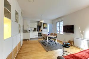 ein Wohnzimmer mit Tisch und Küche in der Unterkunft Superbe appartement 4 personnes Arcachon Abatilles avec parking 500m plage Péreire in Arcachon