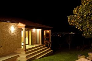 una pequeña casa con porche por la noche en O MIRADOR da RÍA en Outes