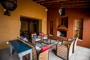 a patio with chairs and tables and a fireplace at Villas Casa de Aves in San Miguel de Allende