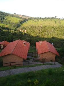 康塞桑依荻波卡的住宿－CHALÉ Nativo R do Céu nº 106，山上两个带红色屋顶的谷仓