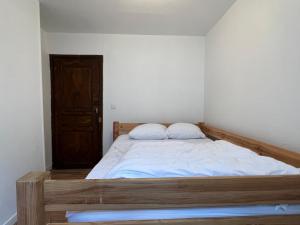 - une chambre avec un lit en bois et 2 oreillers dans l'établissement Au coeur de Cauterets, T2 + alcôve. 4P., à Cauterets
