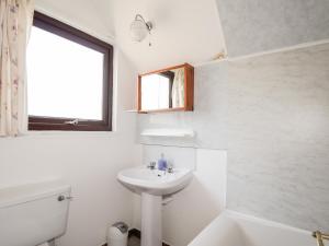 un bagno bianco con lavandino e finestra di Greshornish Boathouse a Edinbain