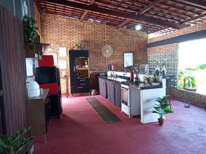 a kitchen with a stove and a counter top at Casa Aconchegante Estilo Rústico na Praia in Barra de São Miguel +11 photos