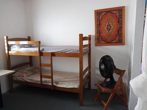 a room with two bunk beds and a fan at Casa Aconchegante Estilo Rústico na Praia in Barra de São Miguel