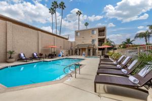 a swimming pool at a hotel with lounge chairs at Best Western Plus Anaheim Inn in Anaheim