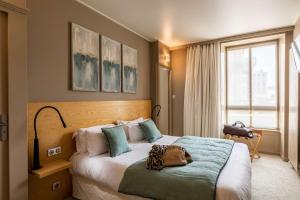 a bedroom with a large bed with a green blanket at Best Western Grand Hotel de Bordeaux in Aurillac