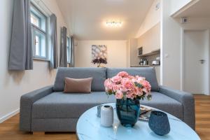 een woonkamer met een bank en een vaas met bloemen op een tafel bij Hidden Art Boutique Residence in Praag