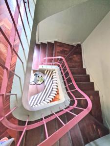 a spiral staircase with pink railings in a building at ASPA - São Paulo Studios in Funchal