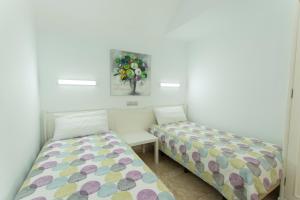 a bedroom with two beds and a painting on the wall at Serenity Garden in Maspalomas +78 photos