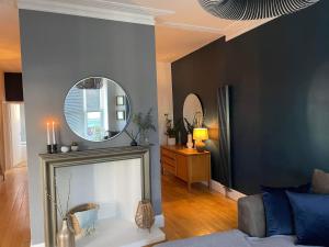 uma sala de estar com um espelho e um sofá em The Clock Tower Apartment - Spacious, Modern, 2 bed Apartment , Southsea with Free parking - sleeps 4 em Portsmouth