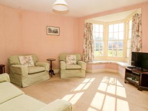 a living room with two chairs and a television at Carr Cottage in Boynton