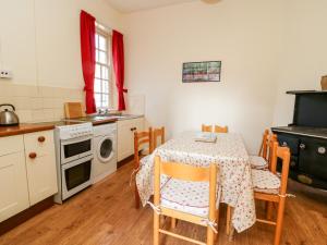 a kitchen with a table with chairs and a stove at Carr Cottage in Boynton