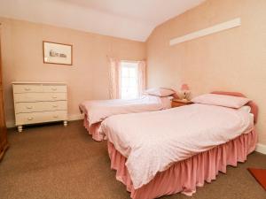 a bedroom with two beds and a dresser and a window at Carr Cottage in Boynton