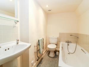 a bathroom with a toilet and a sink and a bath tub at Carr Cottage in Boynton +20 photos