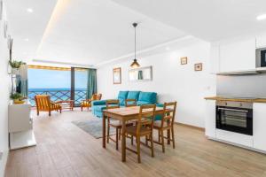 uma cozinha e sala de estar com mesa e cadeiras em Neptuno ocean front suite em Puerto de Santiago