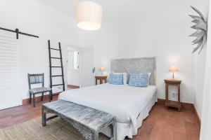 a bedroom with a bed and a ladder and a chair at Casa Prainha, Alvor para 10 pessoas in Alvor +84 photos