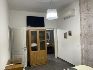 a room with a wooden door and a television on the wall at B&B Casa Dolce Luna in Cosenza