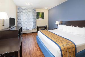 a hotel room with a large bed and a desk at Days Inn by Wyndham Macon I-75 North in Macon