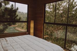 1 dormitorio con 1 cama grande y ventanas grandes en Cabañas Refugio Himalaya, en Guatapé